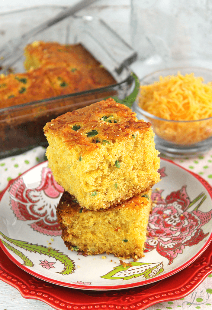 Vertical image of stacked pieces of fluffy cheesy jalapeno cornbread on a beautiful plate.