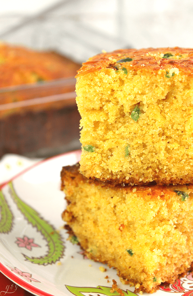 Detailed photo of Cheesy Jalapeno Cornbread showing specks of diced jalapeno and browned cheddar cheese on top. 