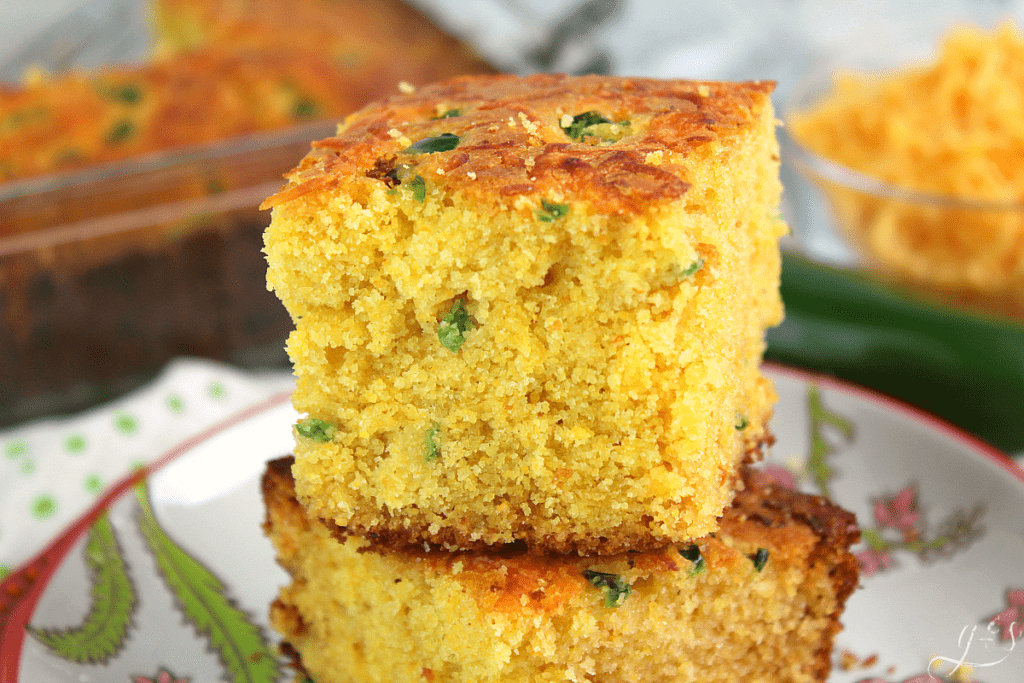 Two pieces of stacked Jalapeno Cheddar Cornbread on a floral plate. 