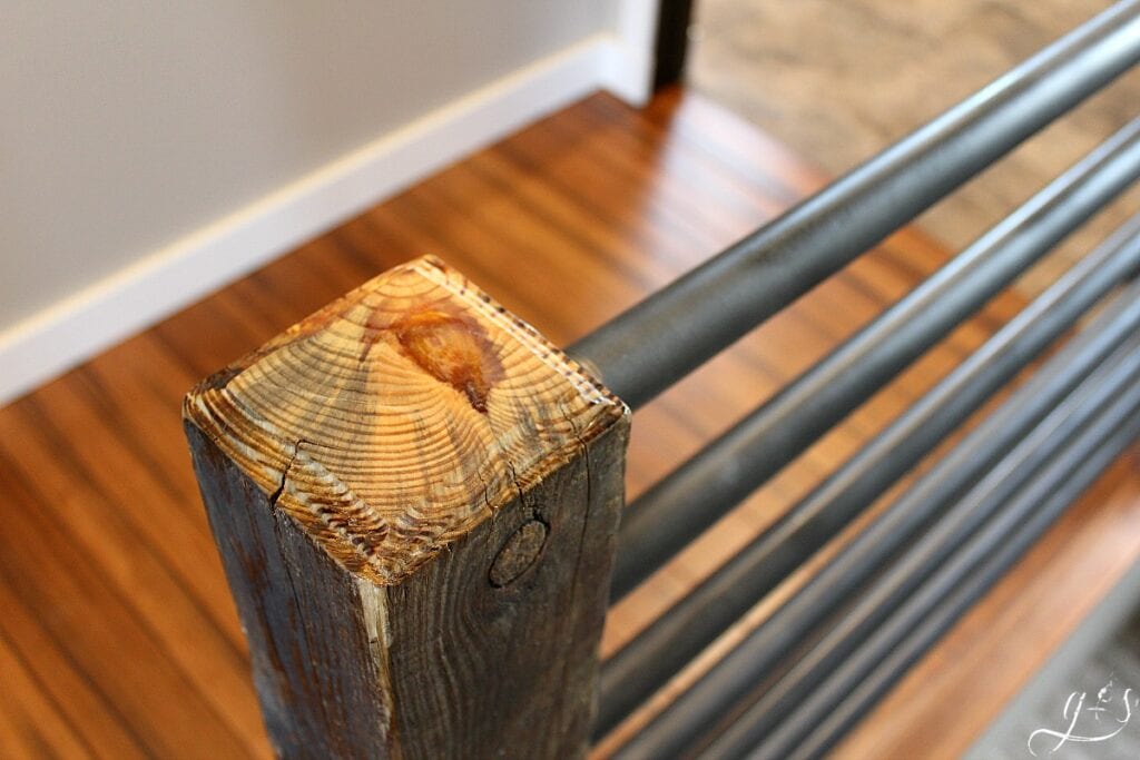 The top of a reclaimed wood post for an industrial stair banister.