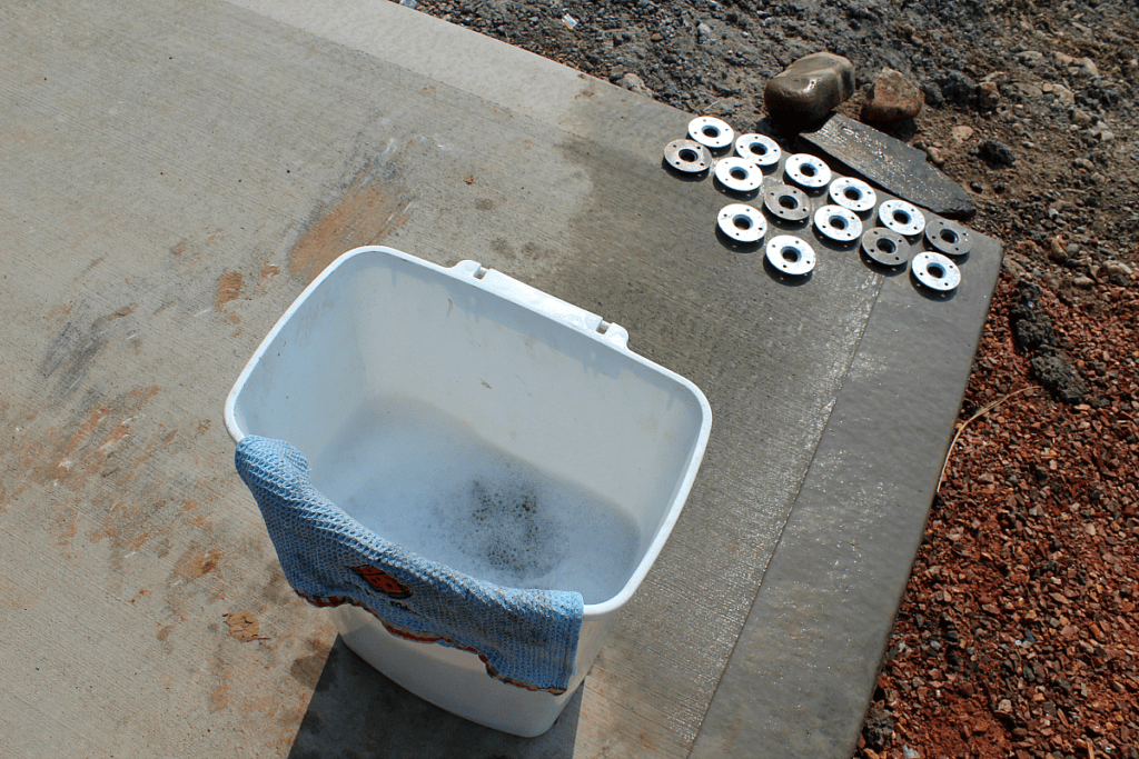 Garbage can full of warm water and soap to wash grease and oil off of steel railings.