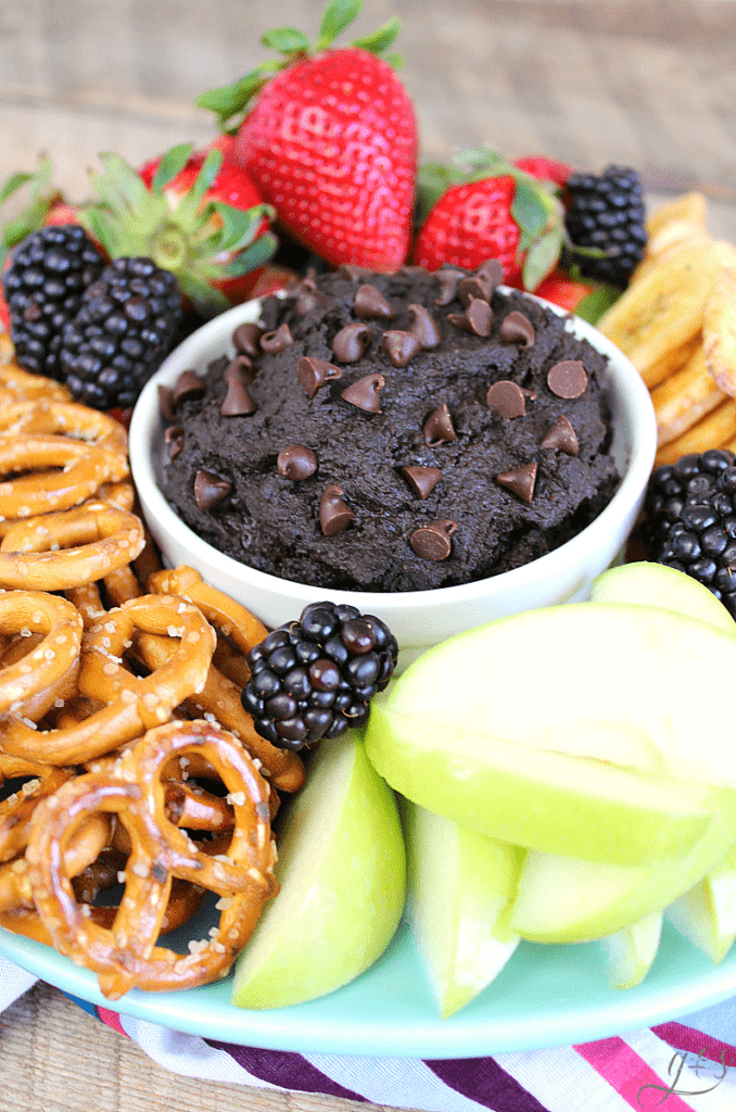 The BEST Brownie Batter Hummus | This clean eating homemade recipe makes the perfect snack or dessert. Healthy, gluten free, and chocolate- what more could you want?! It tastes like frosting or dark chocolate cookie dough! Chickpeas (garbanzo beans), honey, peanut butter (nut butter), and cocoa powder make the most indulgent and easy fruit dip EVER. Dippers to use: berries, apples, Nilla wafers, pretzels, dried banana chips! #recipes #snacks #sweets