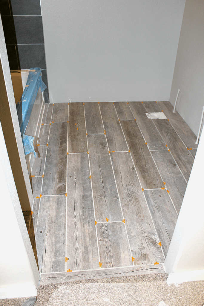 Photo of completed tile floor planks in bathroom with 1/4" spacers. 