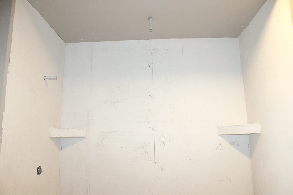 Shower walls with measurements for installing tile. 