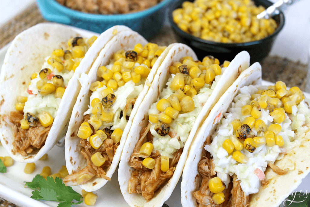 BBQ Chicken Street Tacos using only 5 ingredients plated on a taco rack atop a narrow white plate.