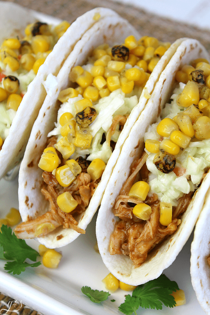 The BEST BBQ Chicken Tacos | This easy 5 ingredient recipe makes the perfect quick weeknight dinner. Rotisserie chicken, barbecue sauce, store-bought coleslaw, a can of fire-roasted corn, and flour or corn tortillas are all you need! Mexican food is a favorite in our family but these summer street taco flavors can't be beat. #bbq #tacos #chicken #dinners #recipes 