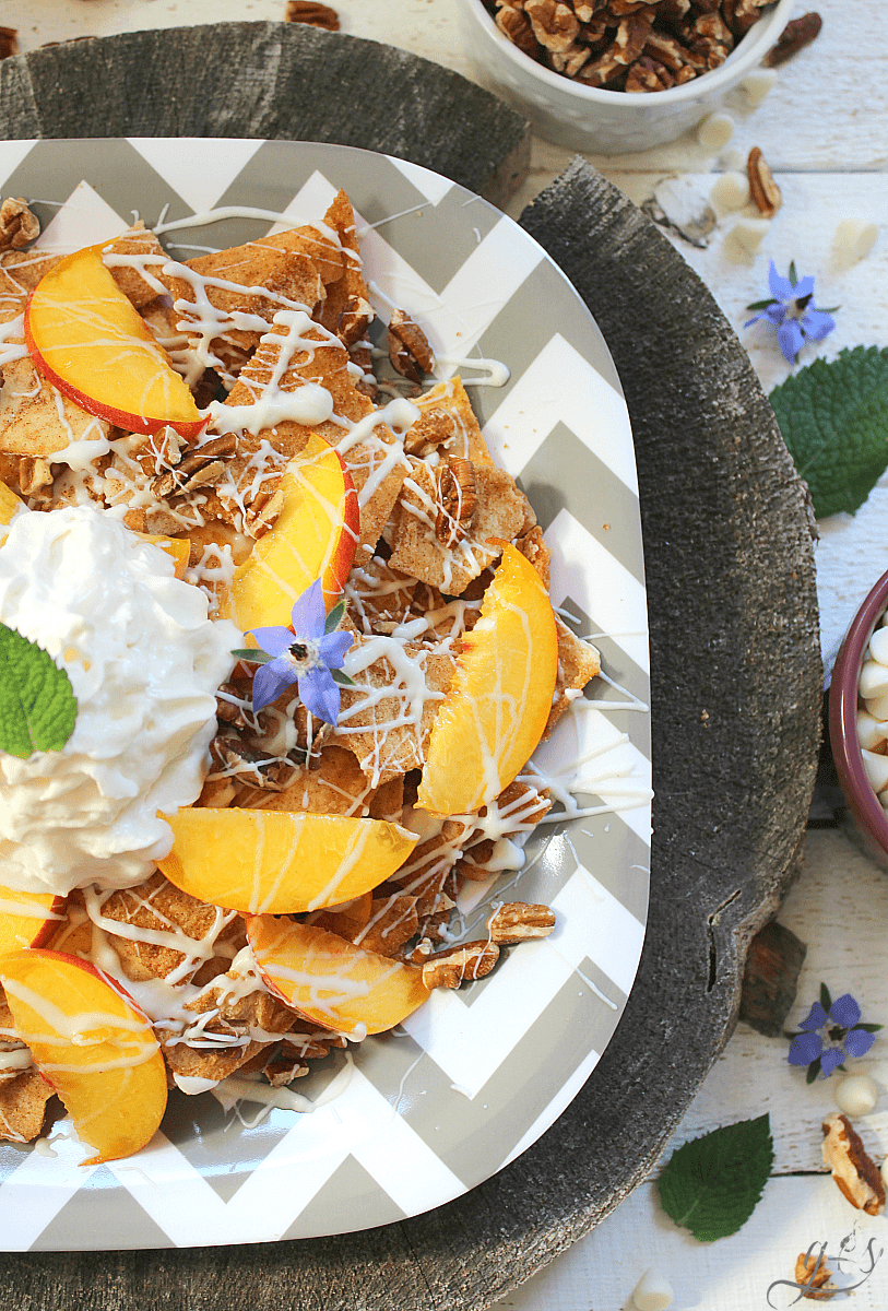 Peach & White Chocolate Dessert Nachos | Cinnamon pita chips, fresh peaches, white chocolate, pecans, and whipped cream comprise the perfect summer recipe. This easy and fun sweets recipe is perfect for a dessert bar at parties and you can even add additional fruit (cherries, blueberries, apple). Try grilling the peaches too for a little smokiness and caramelization! #snacks #SuperBowl #dessert #summer #life