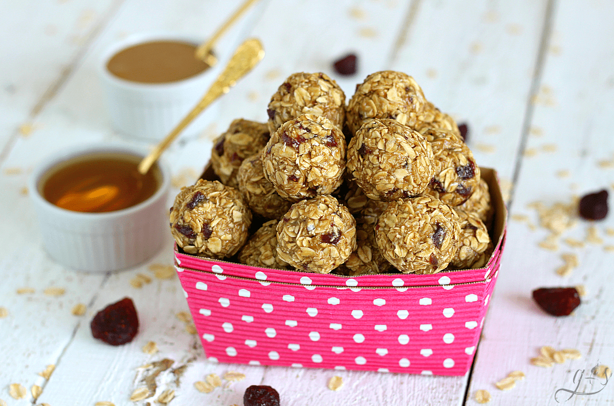 Round "PB&J" energy bites in a pink container ready to be eaten