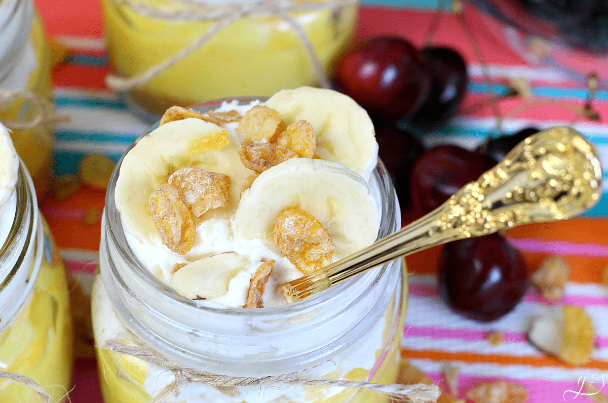 The top of a mason jar pie complete with whipped cream, banana slices, and Honey Bunches of Oats cereal. 