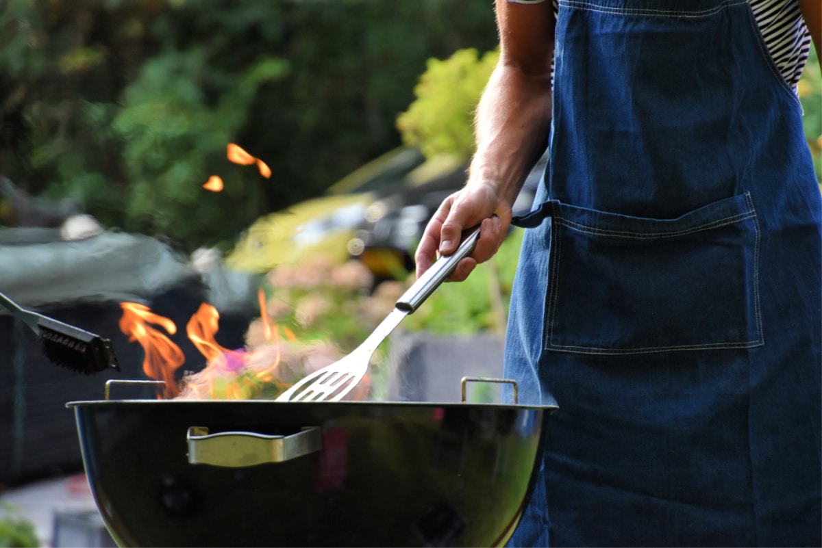 A man grilling on a charcoal grill.