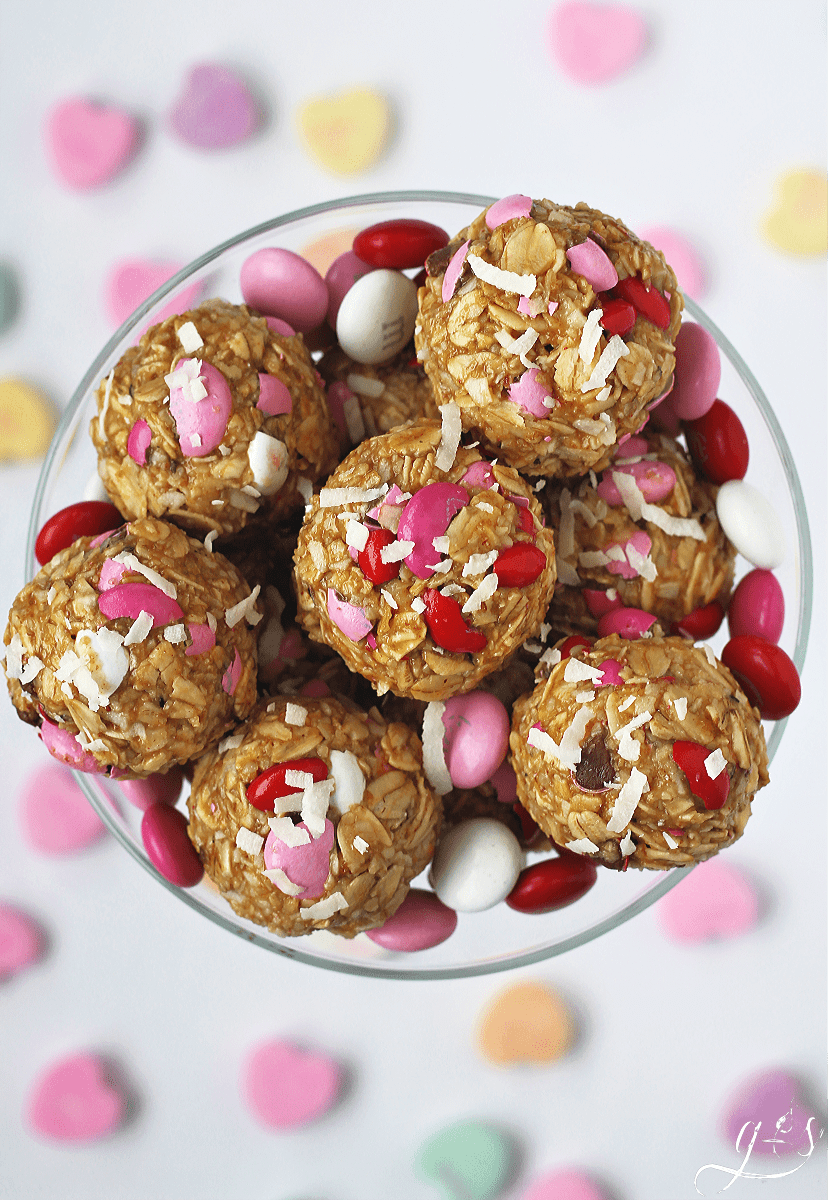 Overhead photo of Valentine No Bake Energy Bites surrounded by M&Ms and conversation hearts.