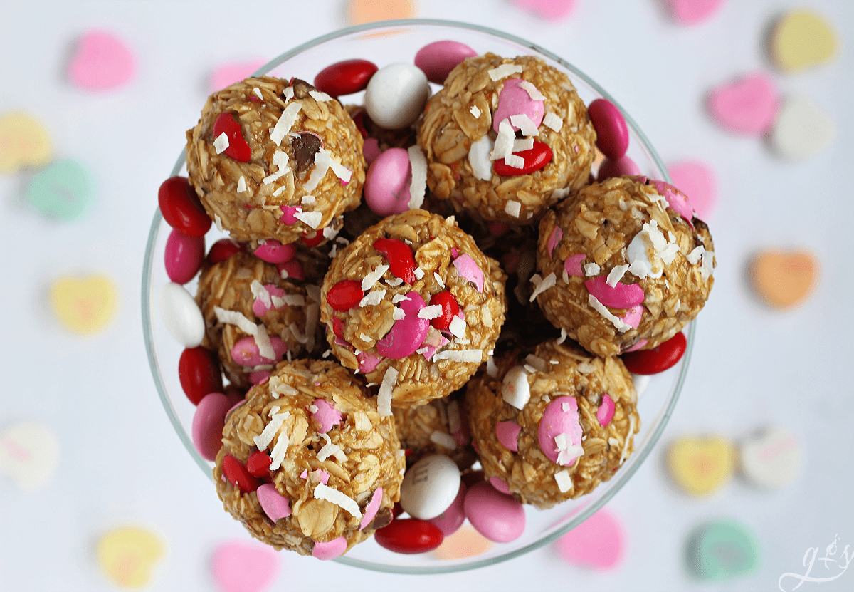 Close up overhead photo of Valentine's Day No Bake Energy Bites surrounded by conversation hearts.