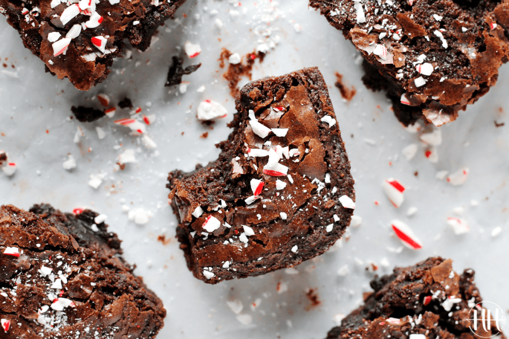 A fudgy peppermint brownie with candy cane dust sprinkled on top and a bite taken out of it.