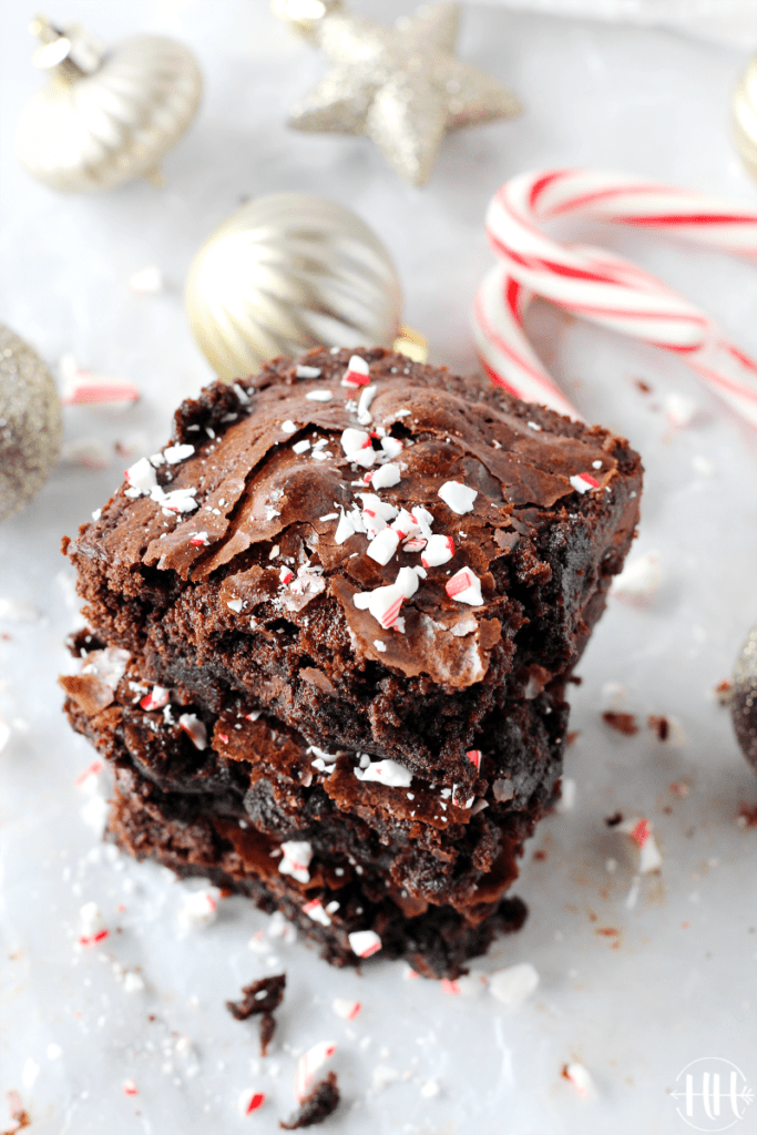 3 Ingredient Christmas Brownies | This easy holiday recipe shows you how to dress up a gluten free boxed brownie mix with a few simple add ins like Young Living Essential Peppermint Oil and crushed candy canes for decoration. These homemade brownies are fudgy, chewy, and packed with chocolate chips! Don't you love kitchen hacks and ideas that use ingredients you already have in your pantry? Serve this cute dessert for kids party, give as a gift to neighbors, or eat them all yourself. #brownies 