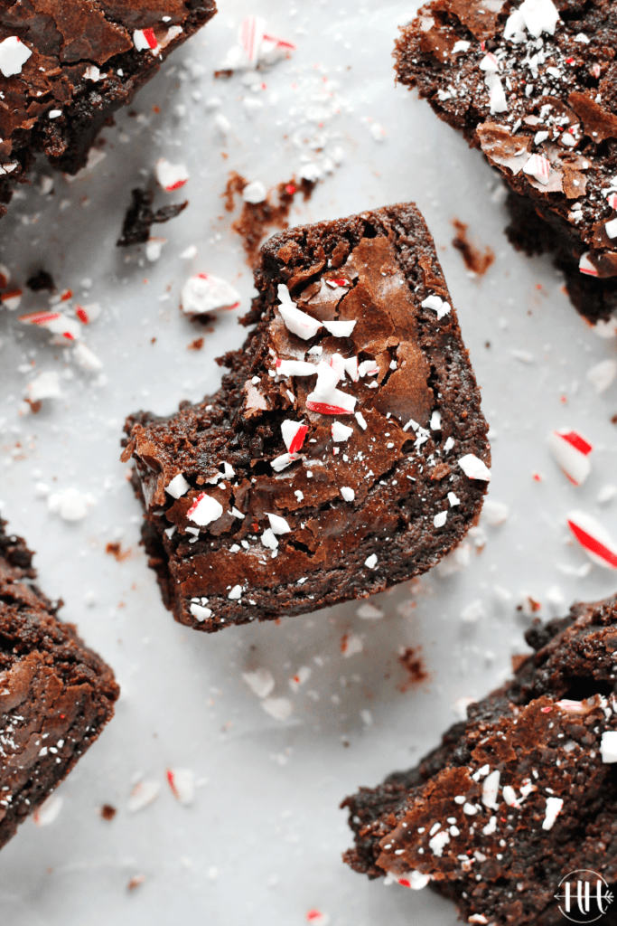 3 Ingredient Christmas Brownies | This easy holiday recipe shows you how to dress up a gluten free boxed brownie mix with a few simple add ins like Young Living Essential Peppermint Oil and crushed candy canes for decoration. These homemade brownies are fudgy, chewy, and packed with chocolate chips! Don't you love kitchen hacks and ideas that use ingredients you already have in your pantry? Serve this cute dessert for kids party, give as a gift to neighbors, or eat them all yourself. #brownies 