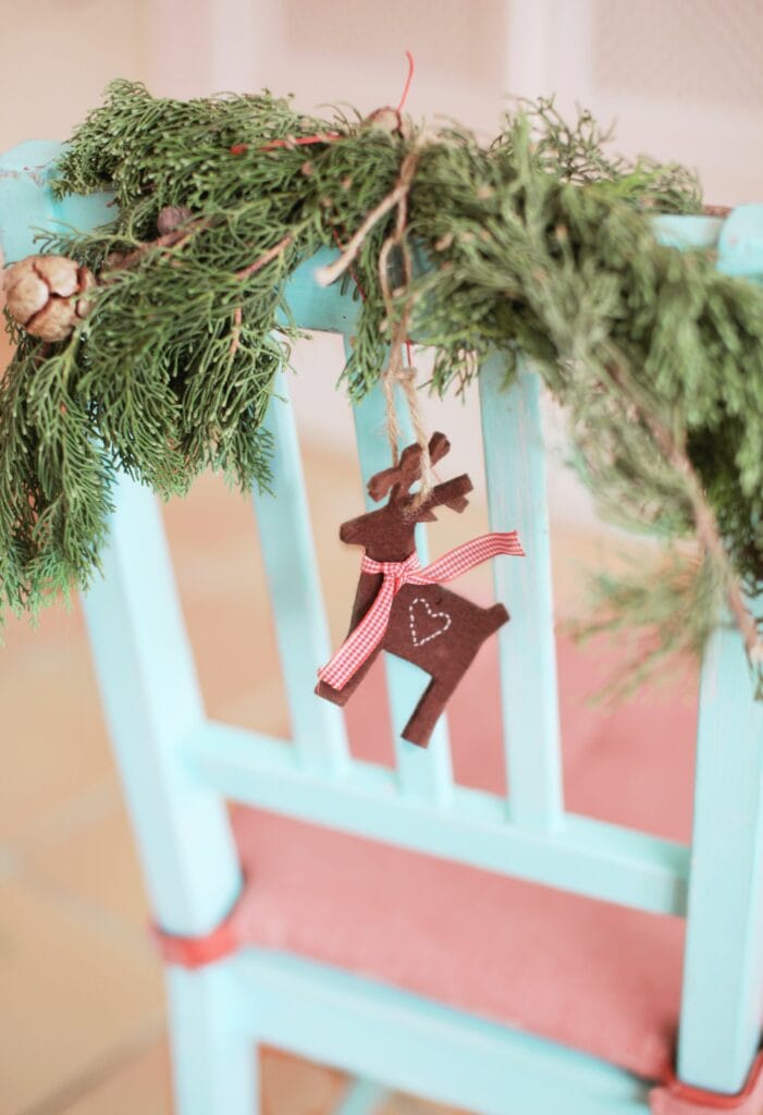 Light blue chair with pine swag and cute reindeer ornament.