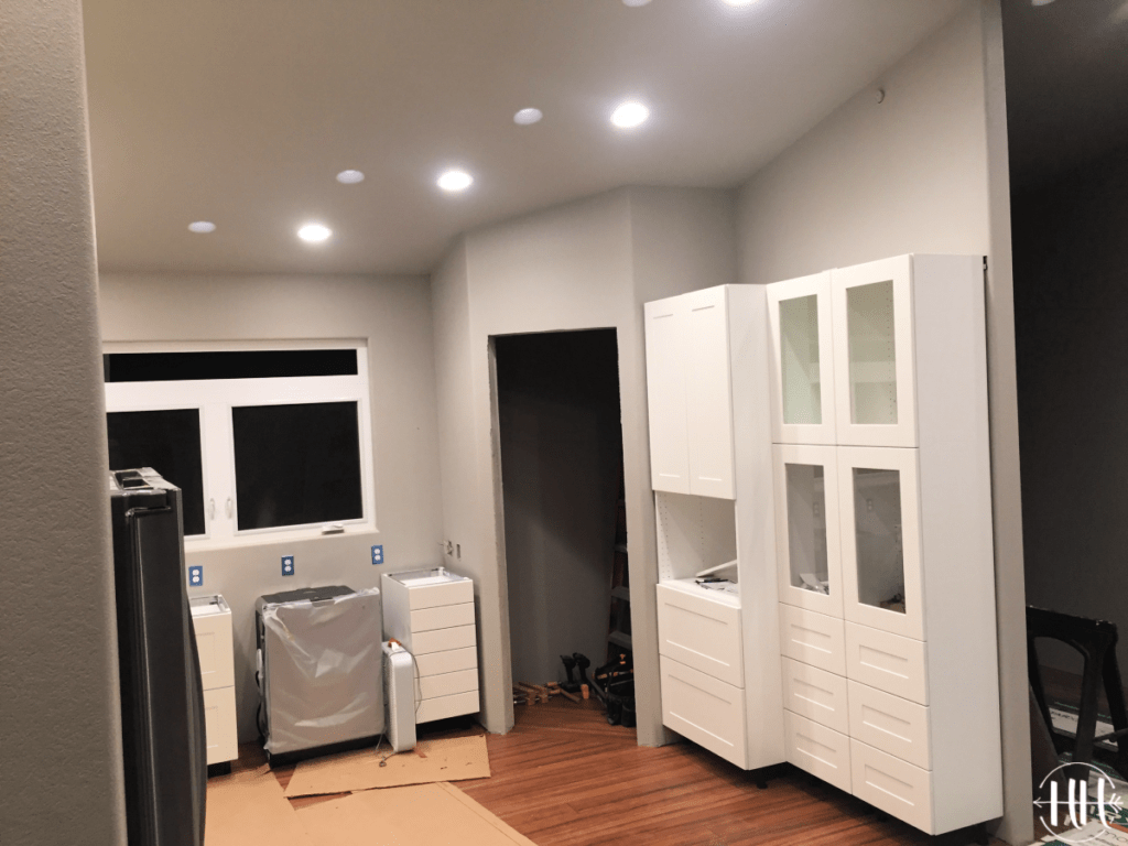 View of kitchen pantry and white microwave cabinet.