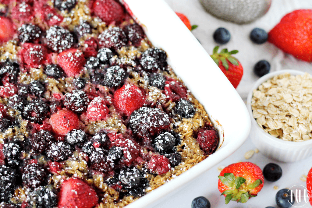 A white 9x13 pan of baked oatmeal with blueberries, strawberries, and raspberries. 