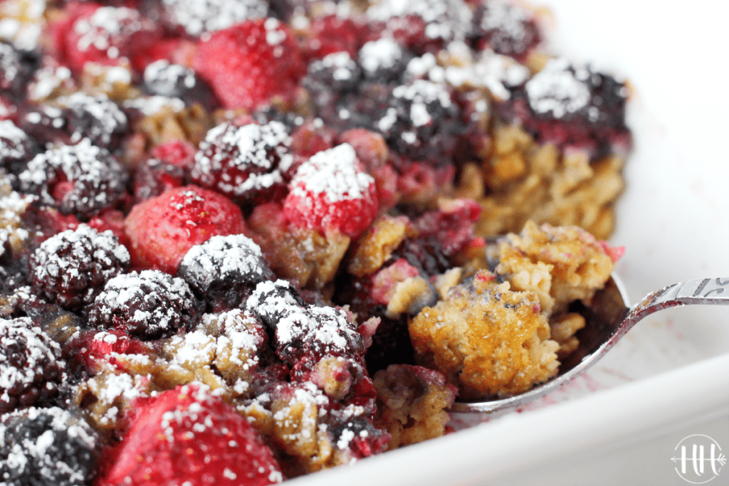 A spoon of baked oats in the pan. Pretty berries on top. 