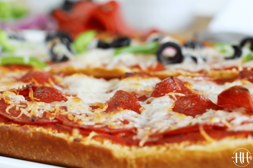 Up close shot of a pepperoni pizza with a crust of French bread.