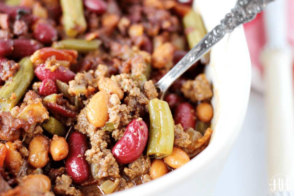 Pinto beans, kidney beans, greens, and hamburger in a homemade sauce make up this potluck side dish.
