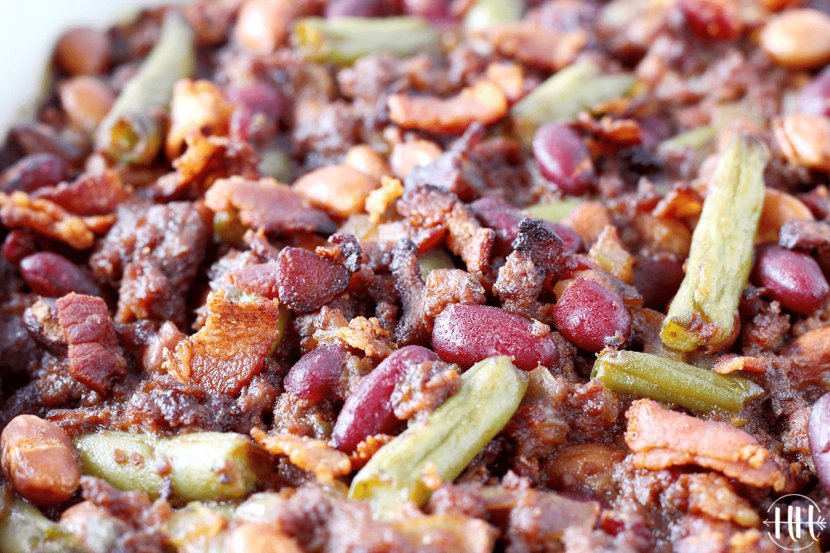 Up close photo of baked red kidney beans, green beans, bacon and ground beef.