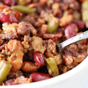 Up close photo of a spoon digging into a pan of calico beans.