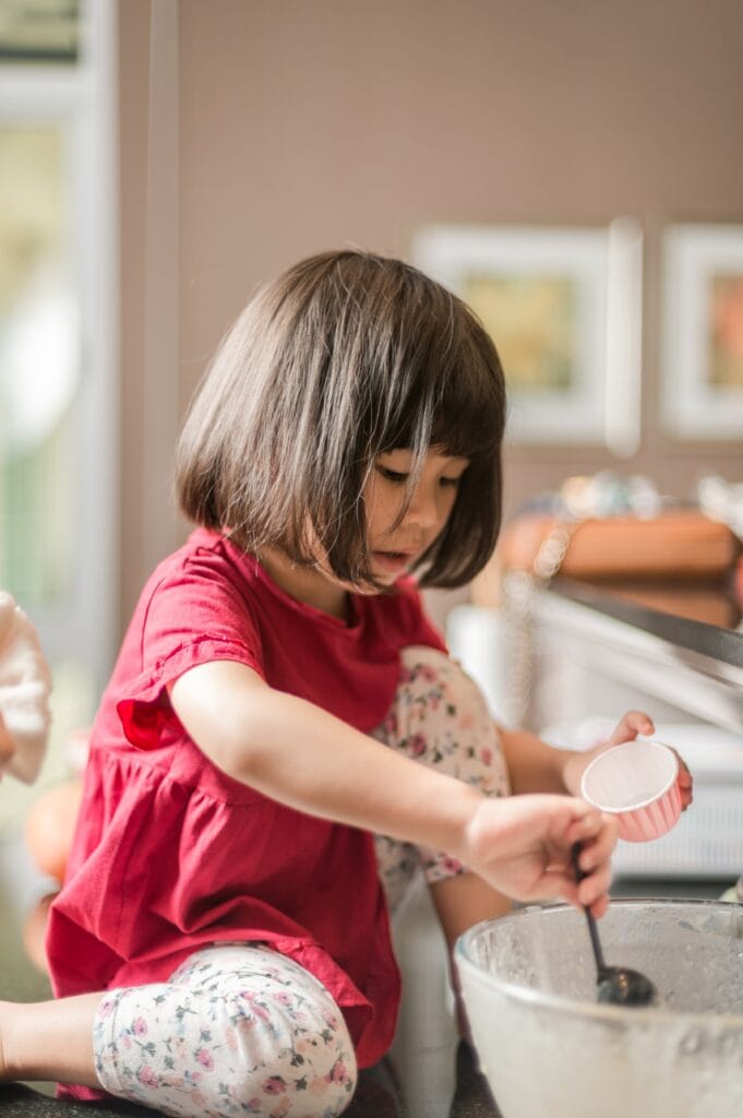 Little girl playing on the kitchen counter.