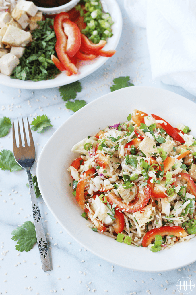 The BEST Chinese Chicken Slaw Salad | This easy no mayo coleslaw recipe is gluten free, dairy free, and refined sugar free. Eat this crunchy cabbage mix for a clean eating Asian lunch or meal prepped no bake dinner. A healthy and simple dressing (spicy chili garlic sauce and rice vinegar) is mixed into the cold coleslaw, bell pepper, and green onion- just add diced chicken (leftover or rotisserie). Serve this in the summer with ramen or without. Make simple subs for Keto, Whole30 and Paleo! 