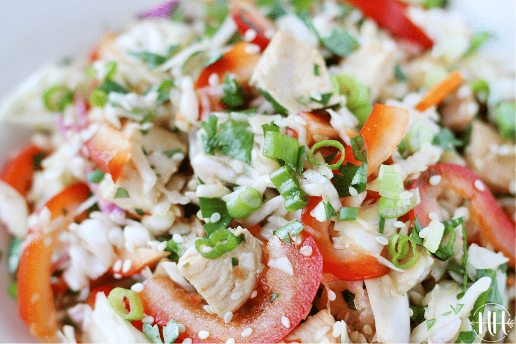 Up close shot of Asian slaw salad topped with white sesame seeds.