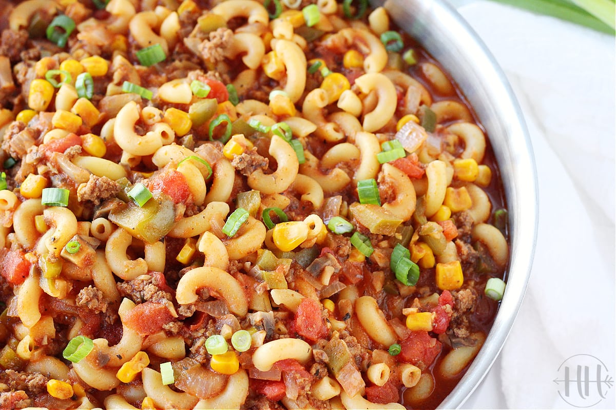 Close up side shot of healthy American goulash garnished with green onion.