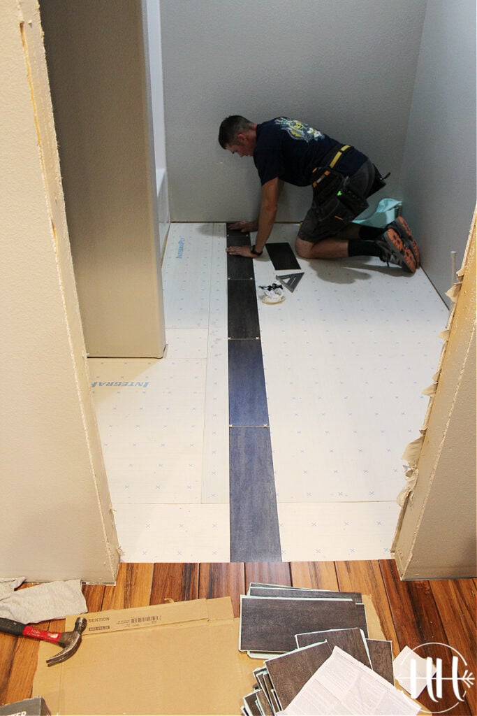 The first row of lvt being installed in a bathroom.