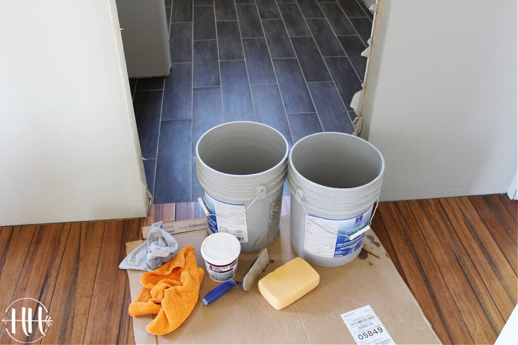 Buckets, sponge, grout float, and grout ready to be used for lvt flooring. 