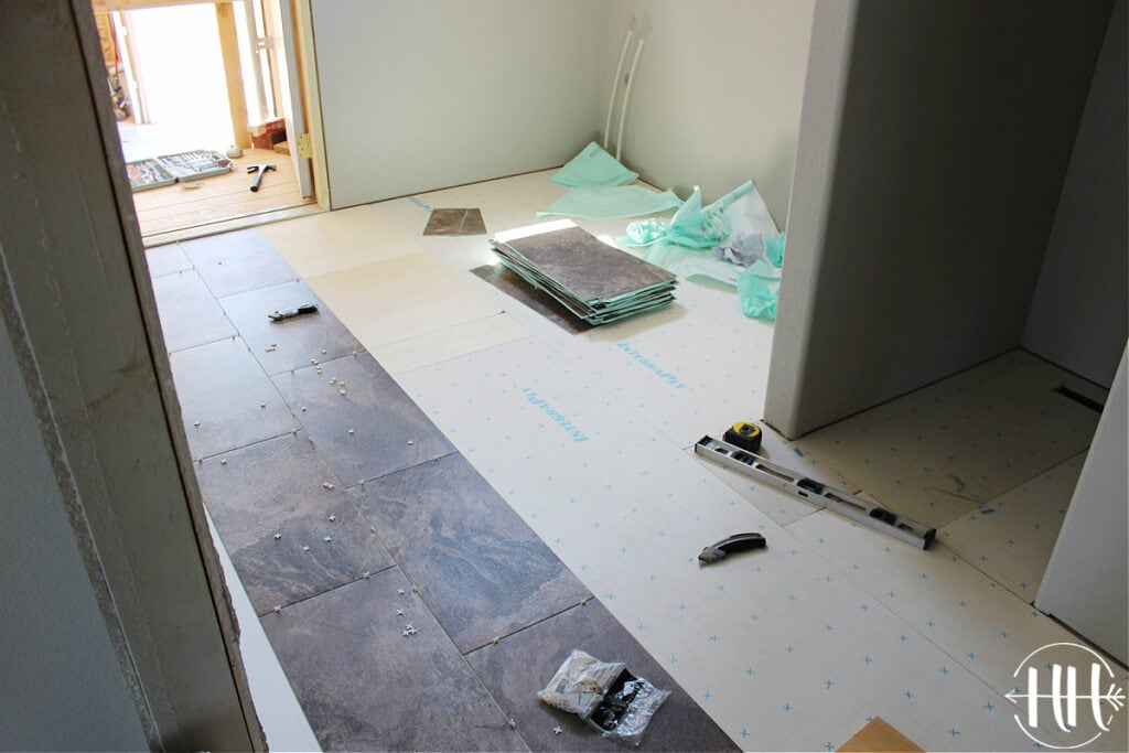 A laundry room and quarter bath with subfloor. LVT planks being laid.