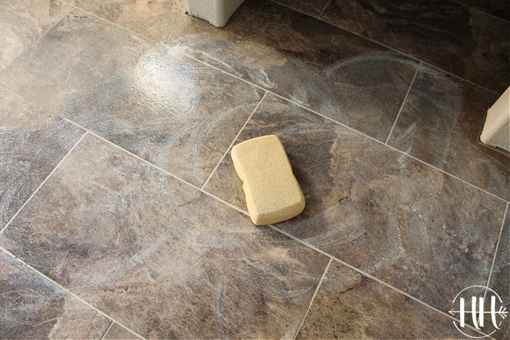 A large soft sponge mopping away the grout residue. 