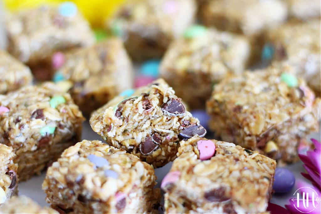 Gluten free Easter M&M's Energy Bars stacked closely together with crushed chocolate candies.