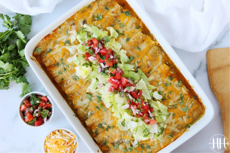 Overhead photo of a 9x13 pan of beef enchiladas in green sauce.