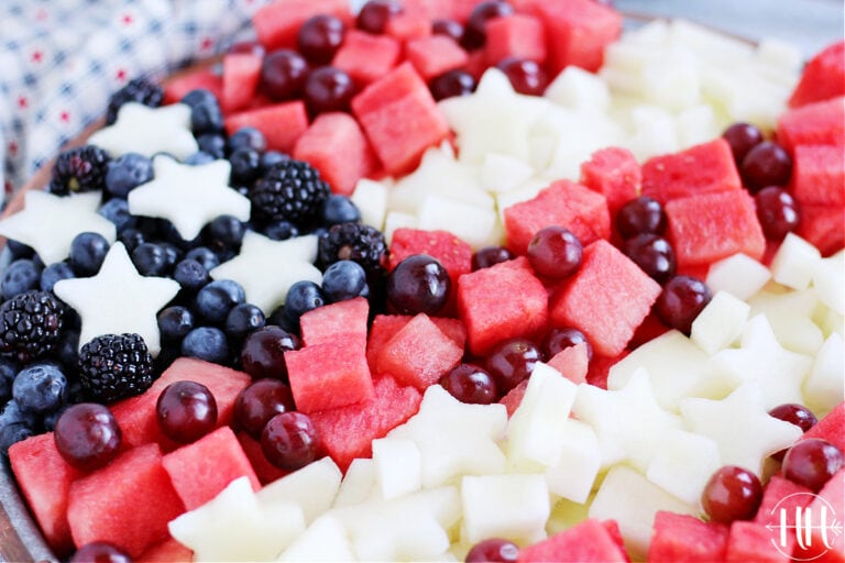 Cubed watermelon, grapes, canary melon stars, fresh blackberries and blueberries arranged on a tray.