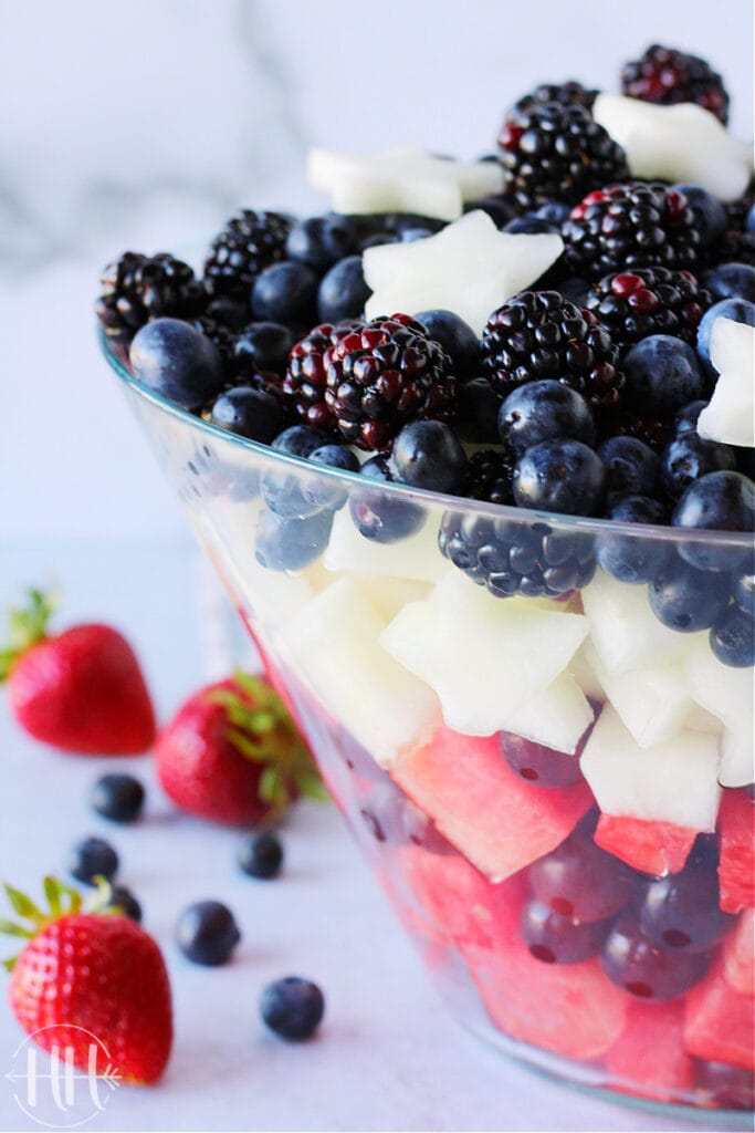 White canary melon star cutouts on top of blueberries and blackberries for a red white & blue fruit salad.