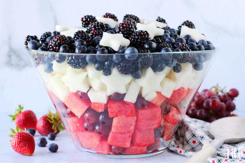 Beautiful glass fruit bowl filled with patriotic colored fruit for Memorial Day. 