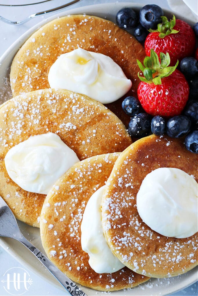 Up close photo of dairy free protein pancakes sprinkled with powdered sugar.