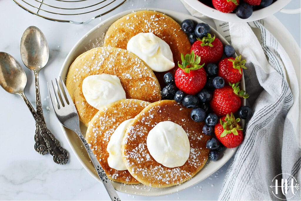 Pretty breakfast scene of healthy pancakes topped with yogurt and fresh berries. 