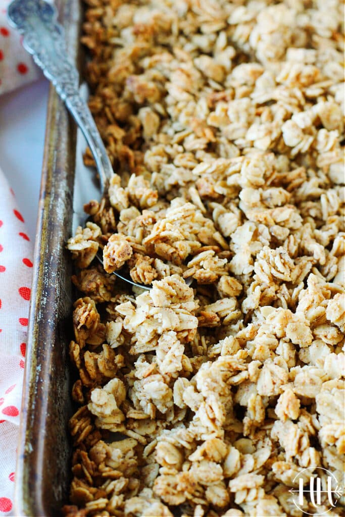 Pan of dairy free granola with an old silver spoon. 