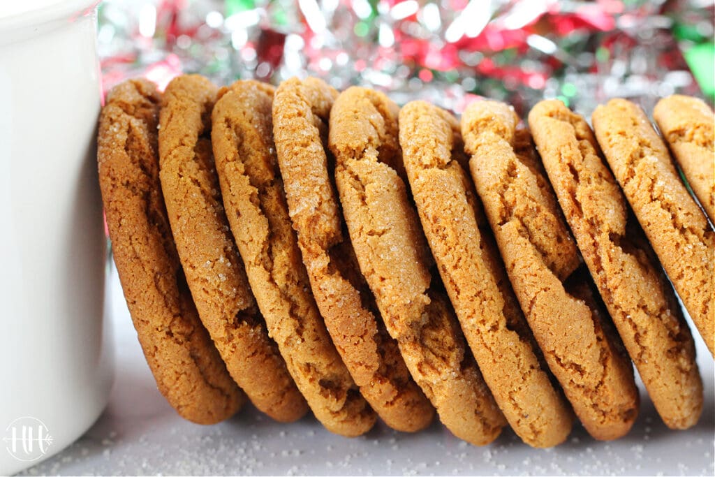 Molasses Crinkles Cookies stacked upright against a white mug.