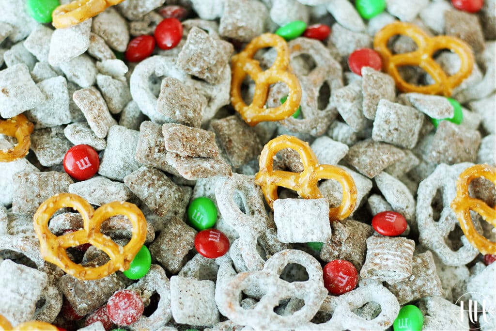 Pan of chocolate and Sunbutter coated Chex cereal rolled in powdered sugar with M&Ms and pretzels.