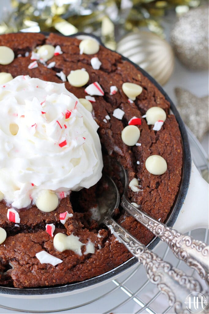 A pretty holiday cake that is also healthy in a glazed cast iron pan topped with whipped cream and crushed candy canes.