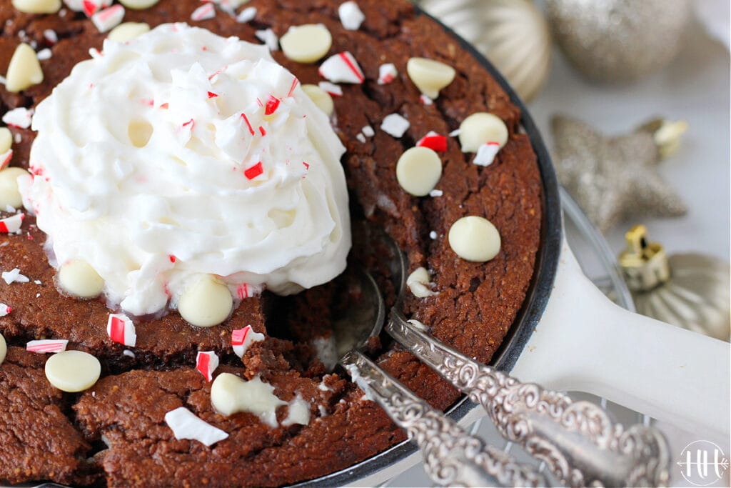 Holiday protein cake surrounded by glittering Christmas ornaments and garland.