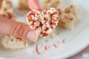 Up close photo of a heart shaped rice krispie treat with cranberry seeds.