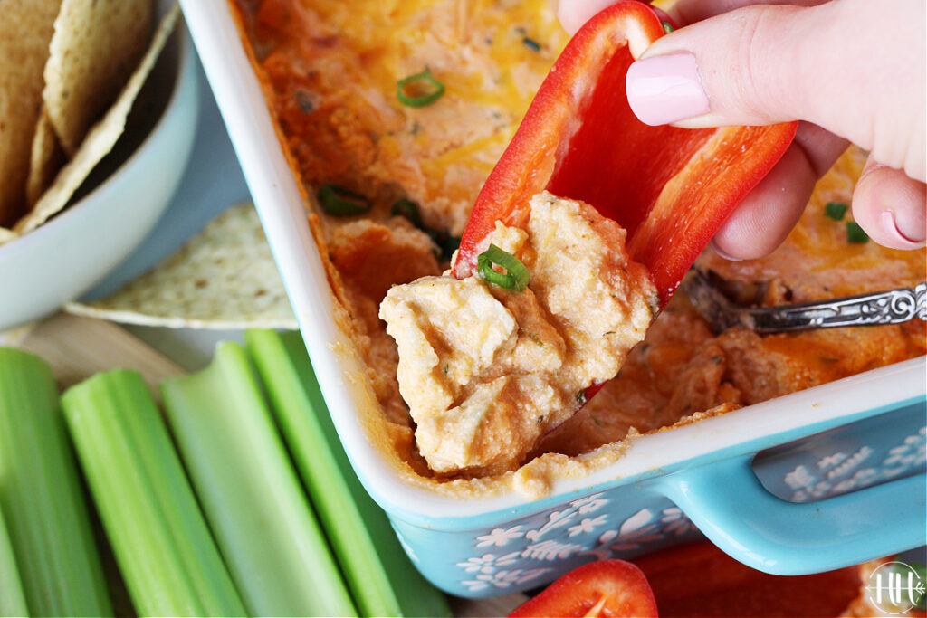 Mini red bell pepper dipped in an easy buffalo chicken dip.