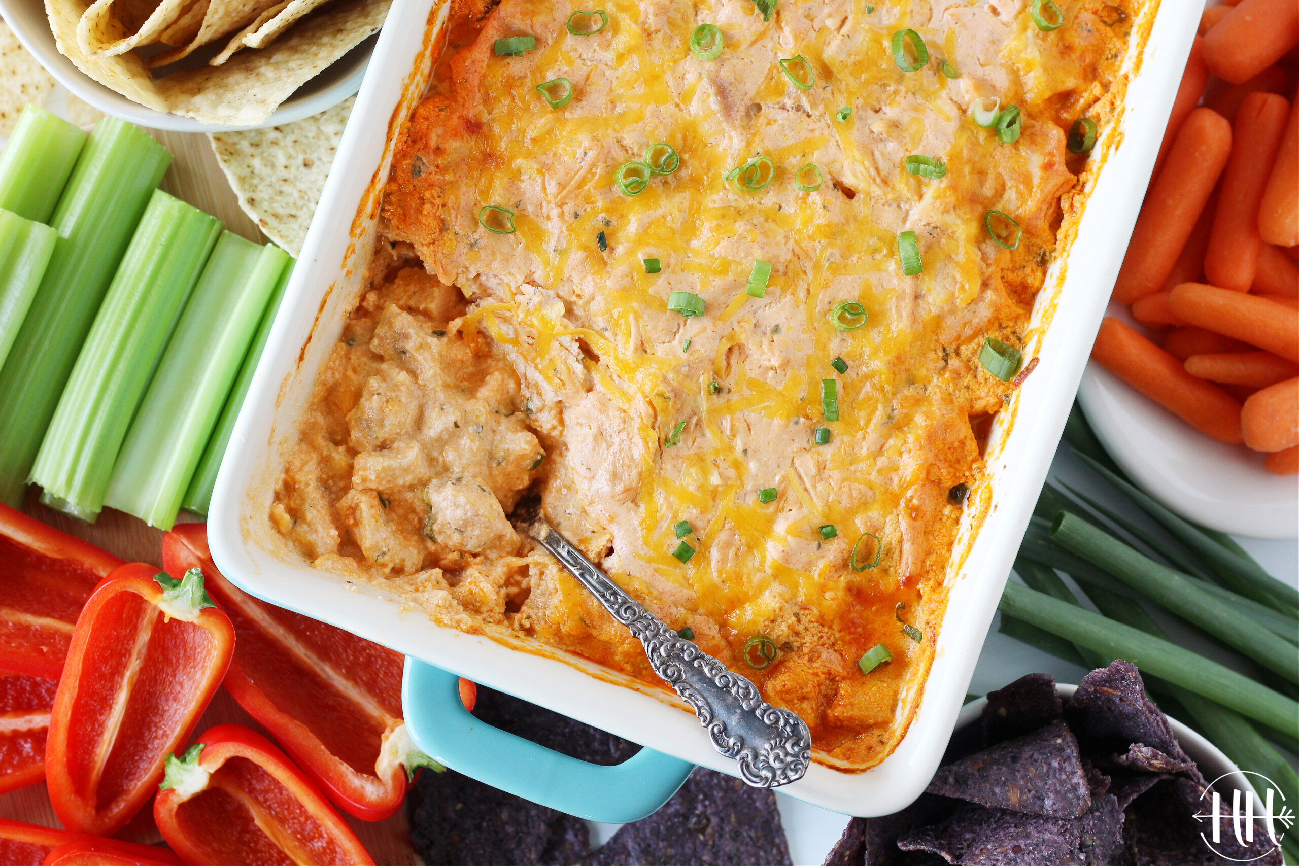 Overhead photo of a pan of high protein buffalo chicken dip topped with green onions.